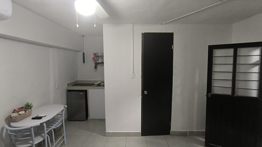 Imagen pequeña de la mesa, cocineta, puerta del baño y puerta principal