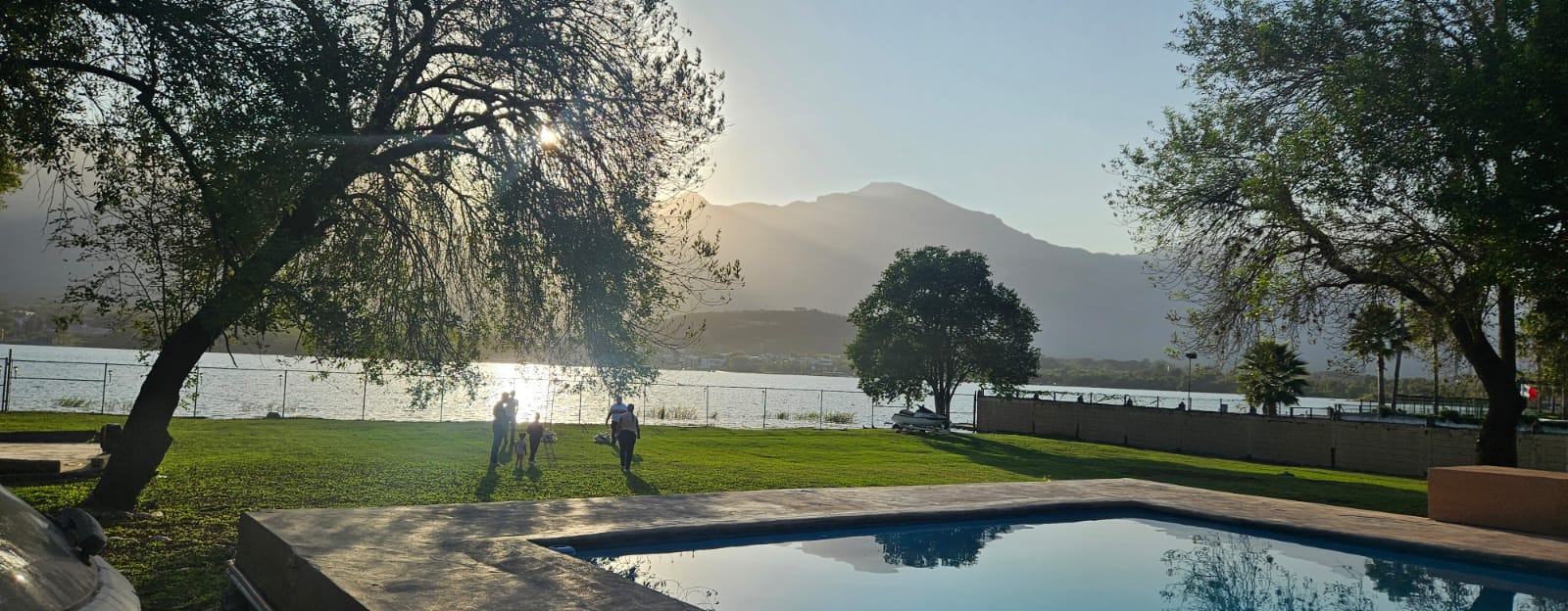Imagen pequeña de la quinta Paraiso donde se ve parte de la alberca, el jardín en el cual se ve conviviendo a una Familia y la presa de la boca