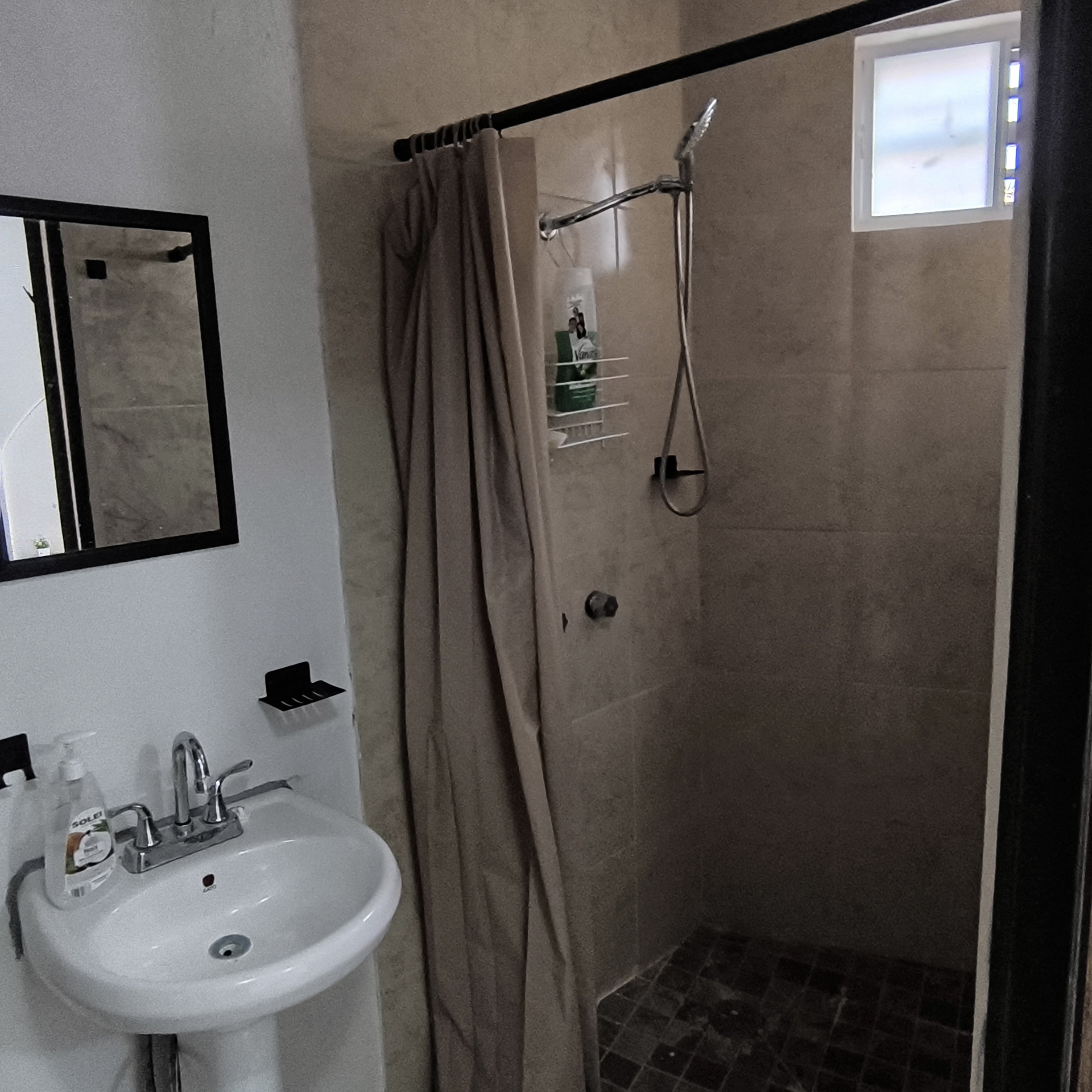 El Loft donde se ve el lavabo, la regadera y el espejo del baño